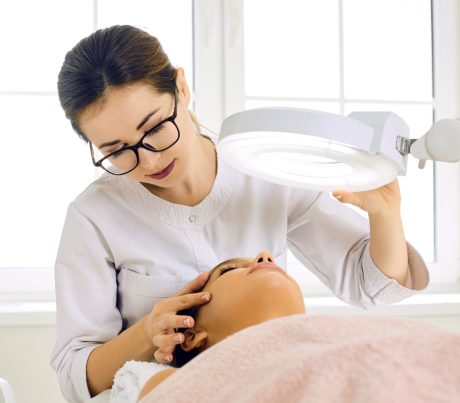 Esthetician providing skincare treatment to a client.