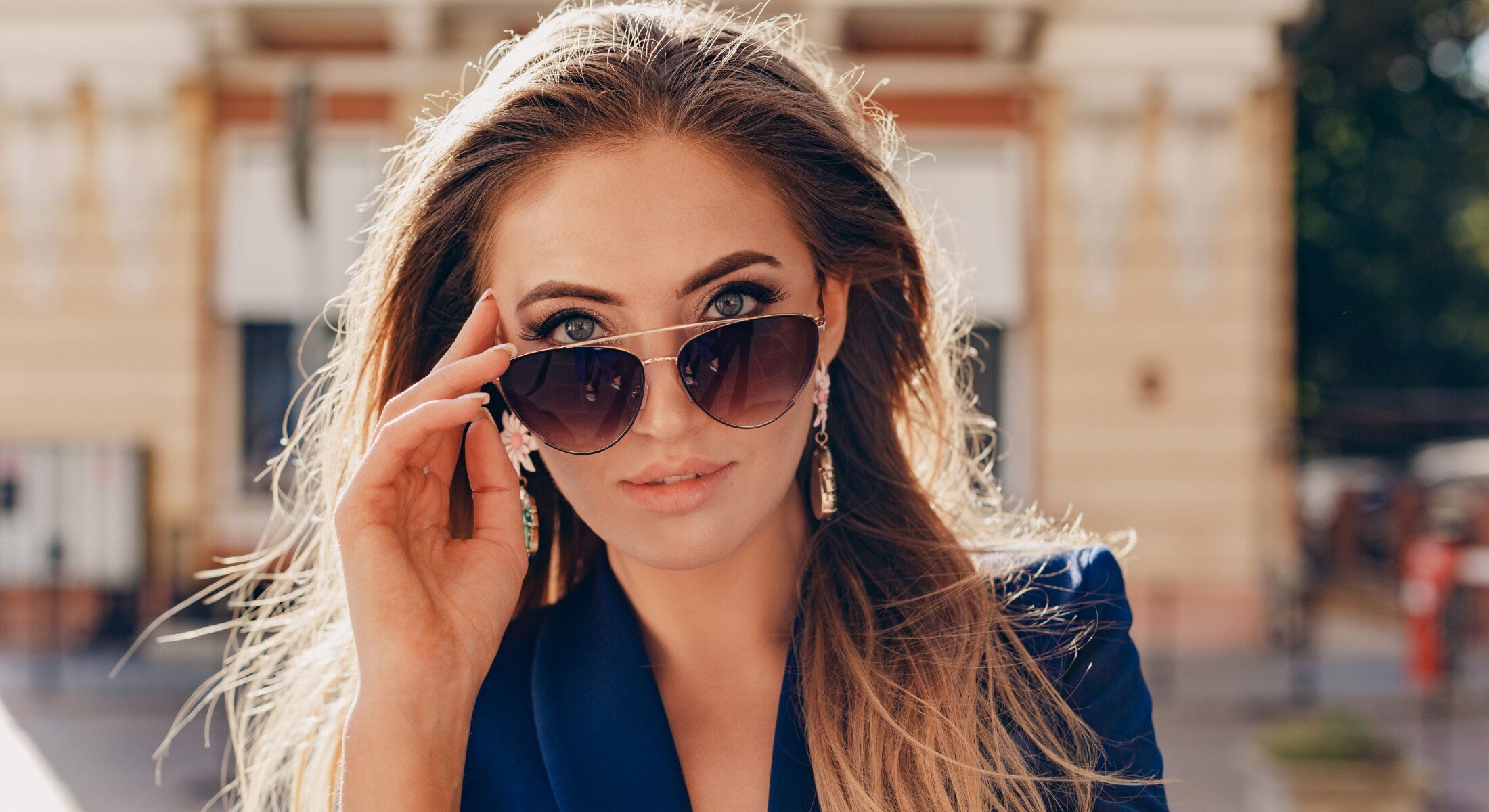Young woman wearing sunglasses and elegant attire.
