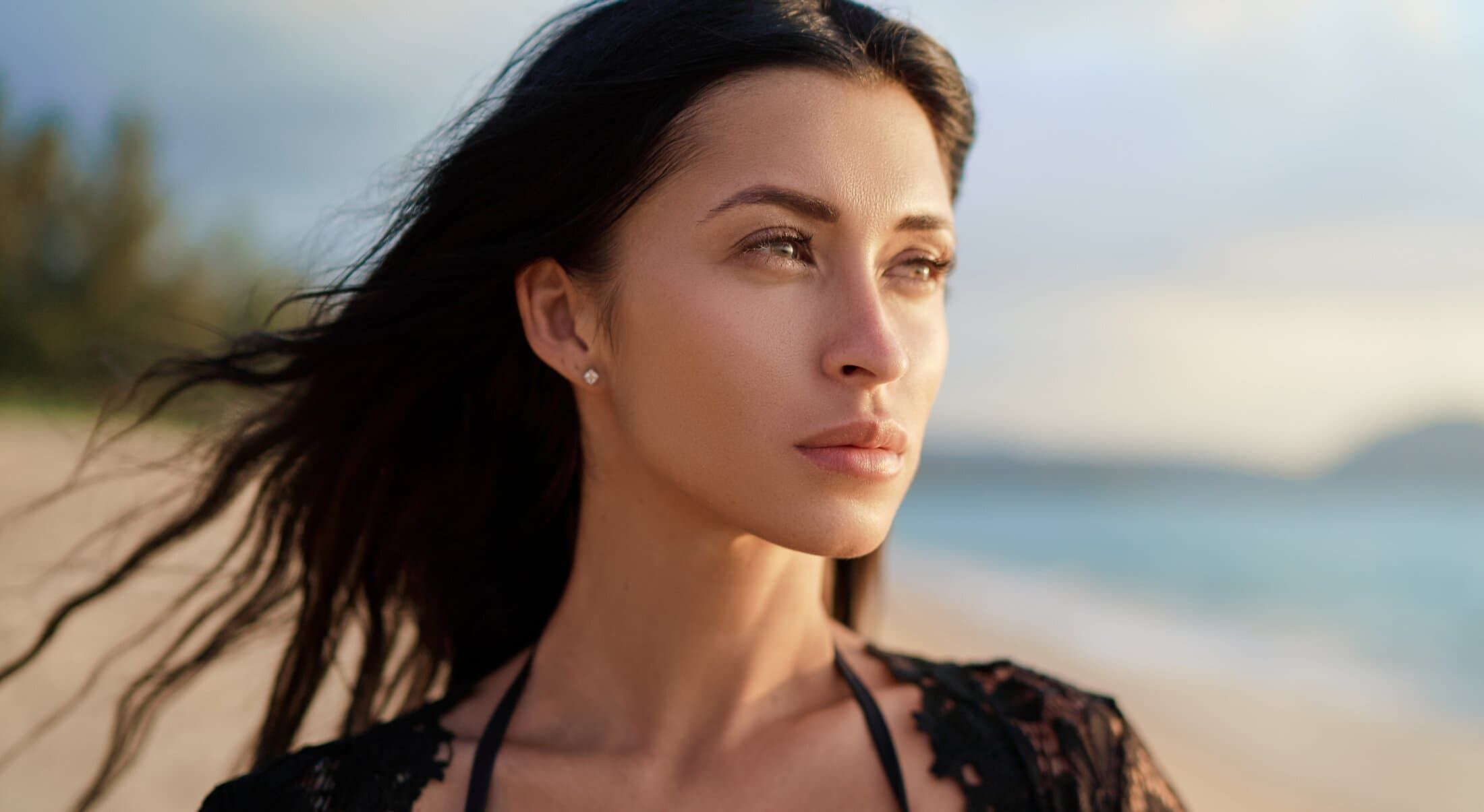 Woman gazing towards the ocean at sunset.