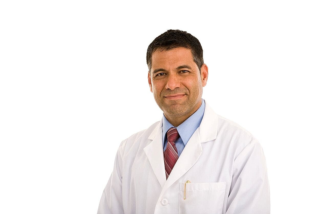 Male doctor smiling in a white lab coat.